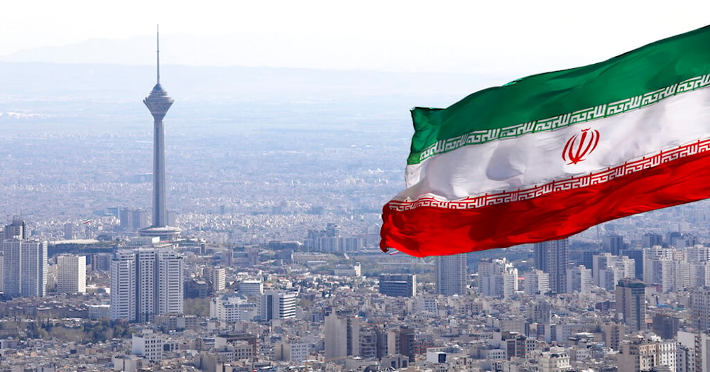Iran's national flag waves as Milad telecommunications tower and buildings are seen in Tehran, Iran, Tuesday, March 31, 2020. (AP Photo/Vahid Salemi) 