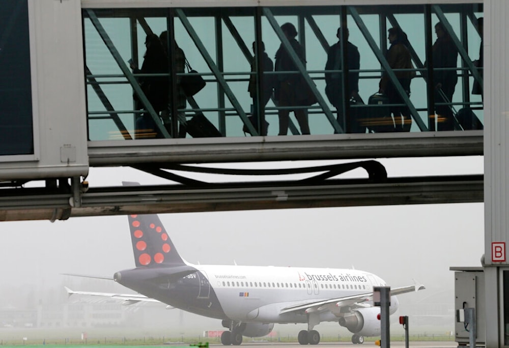 Passengers prepare to board a plane at Brussels international airport on Thursday, Nov. 20, 2014. (AP Photo/Yves Logghe)