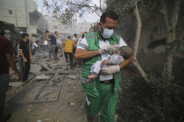 Palestinian medic takes a baby pulled out of buildings destroyed in the Israeli bombardment of the Gaza Strip in Rafah, Sunday, Oct. 22, 2023. (AP