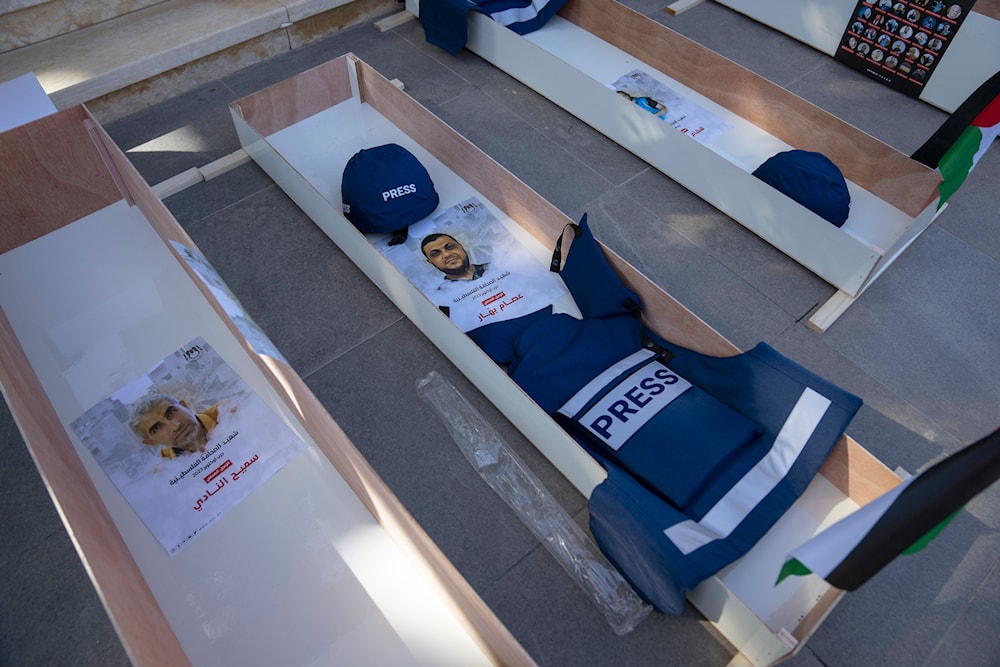 Posters with names and pictures of Sameeh Nadi, left and Esam Bashar,placed in mock coffins of Palestinian journalists who were killed, in the West Bank city of Ramallah, Nov. 7, 2023.  (AP)