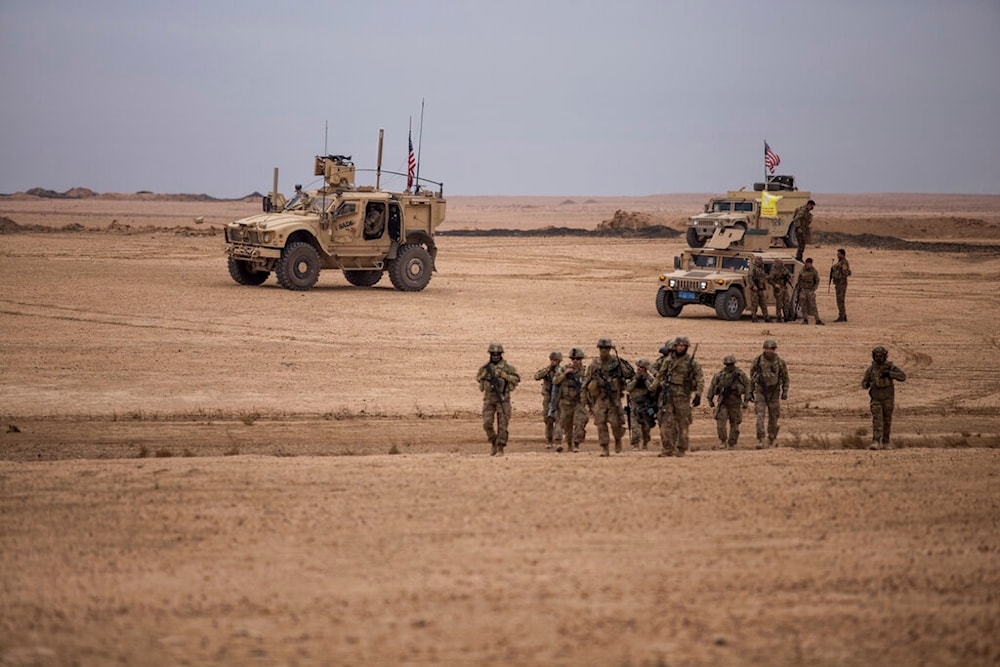 US soldiers walk during a joint exercise with Syrian Democratic Forces at the countryside of Deir Ezzor in northeastern Syria, Wednesday, Dec. 8, 2021 (AP)