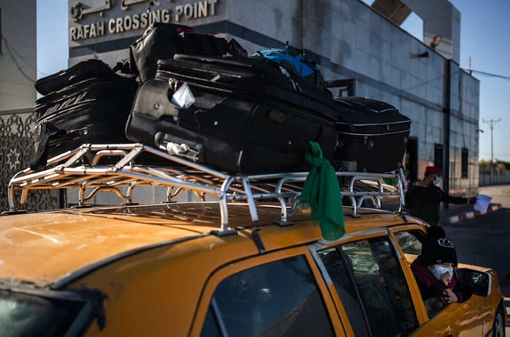 A Palestinian child looks outside a car loaded with luggage as she and her family wait to cross to the Rafah crossing border with Egypt, in the southern Gaza Strip, Monday, Feb. 1, 2021 (AP)