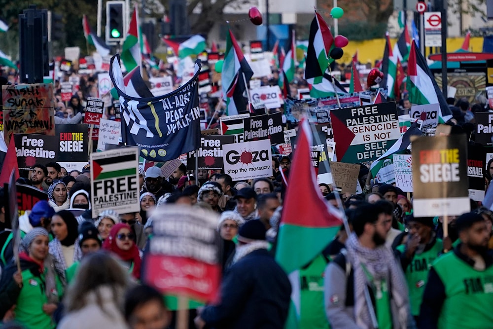 Protesters hold placards during a pro-Palestine protest in London, Saturday, Nov. 11, 2023 (AP Photo/Alberto Pezzali)