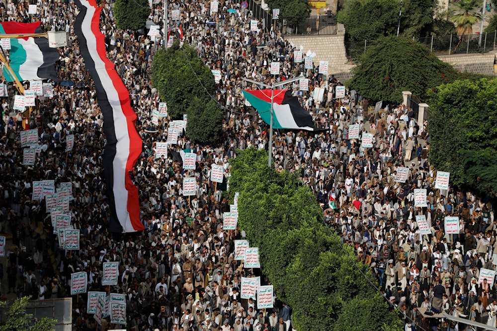 Protesters hold the Yemeni and Palestinian flags, July 4, 2023 (AP)