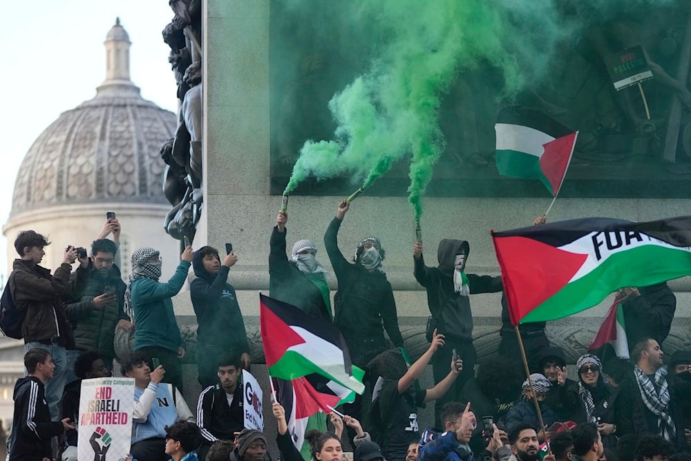 Protesters hold flares during a pro Palestinian demonstration in London, Saturday, Oct. 14, 2023. (AP)