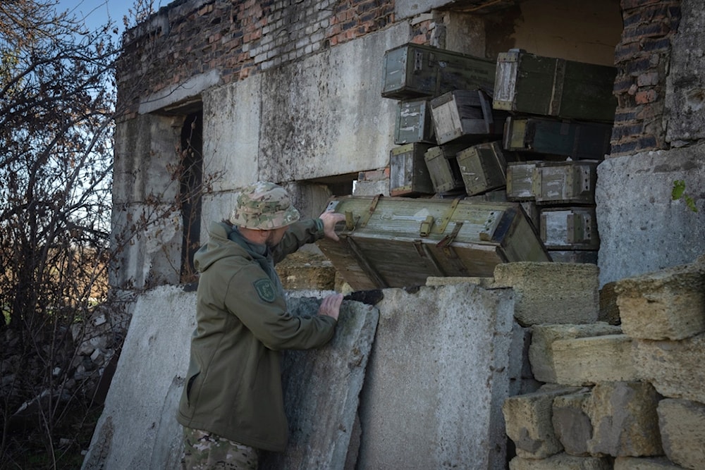 A sapper examines ammunition left by the Russian troops in the village of Kiseliovka close to Kherson, Ukraine, Friday, Nov. 10, 2023.(AP Photo/Efrem Lukatsky)