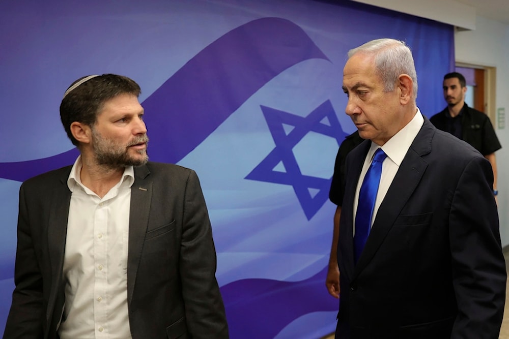 Israeli Prime Minister Benjamin Netanyahu, right, talks with Finance Minister Bezalel Smotrich, left, during the weekly cabinet meeting in the prime minister's office in Al-Quds, June 25, 2023.(AP)