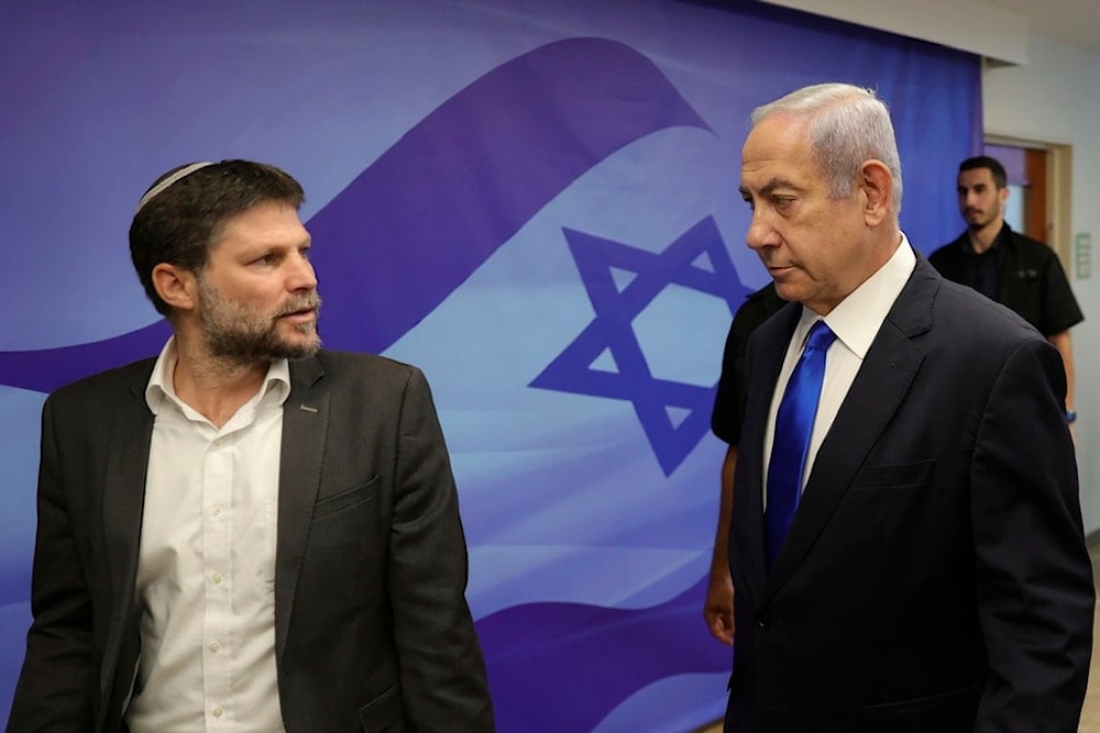 Israeli Prime Minister Benjamin Netanyahu, right, talks with Finance Minister Bezalel Smotrich, left, during the weekly cabinet meeting in the prime minister's office in Al-Quds, June 25, 2023.(AP)