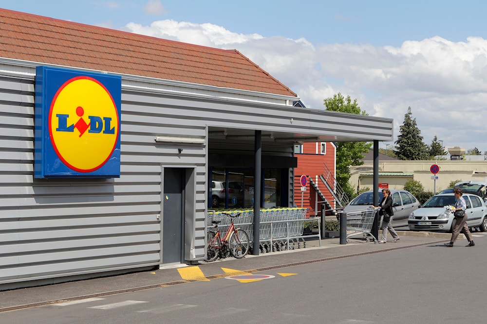 People walk into a Lidl supermarket in Chambourcy, 30 km west of Paris, Thursday, June 16, 2011. (AP)