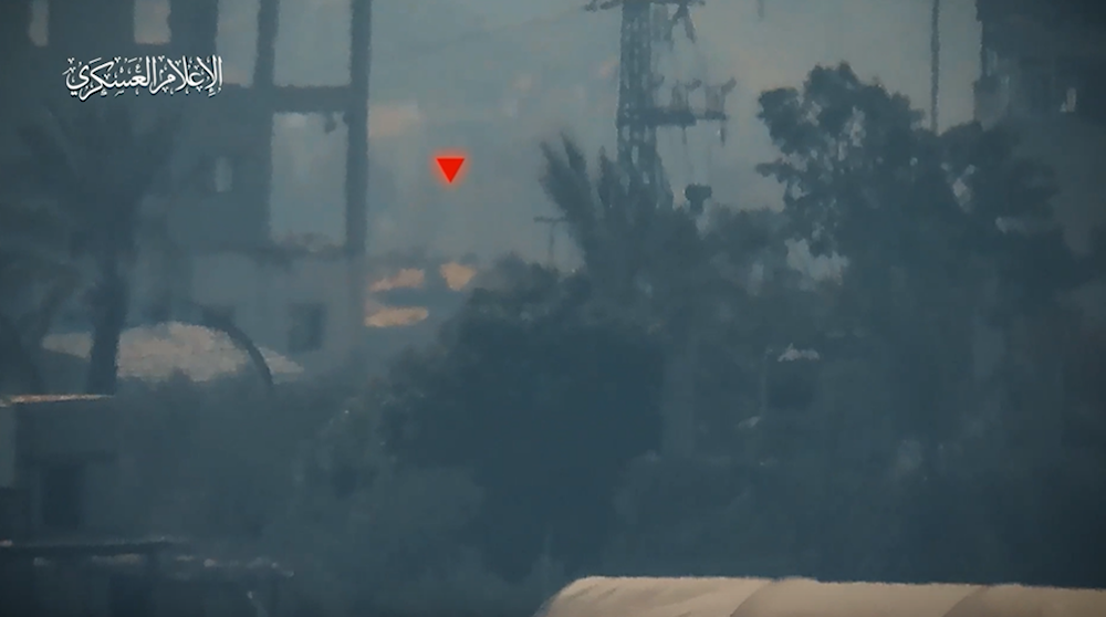 A screenshot from a video released by the Al-Qassam military media on November 13, 2023, depicting an Israeli Merkava tank being marked by the Resistance just before it gets targeted with the proper weapon. (Military media)