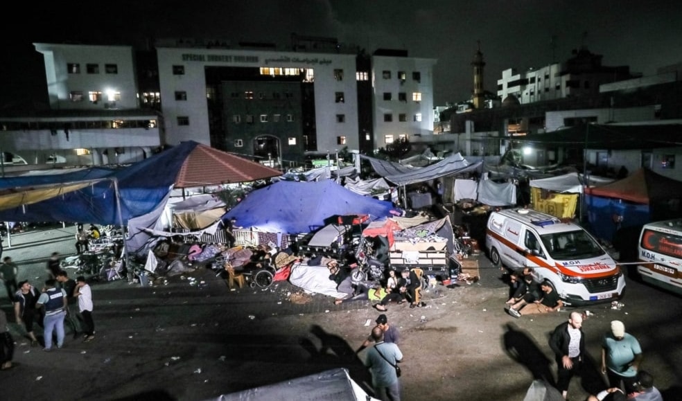 People wait in tent shelters in the darkness as fuel for electricity generation runs out, outside Al-Shifa hopsital in Gaza City early on 3 November 2023. (AP)