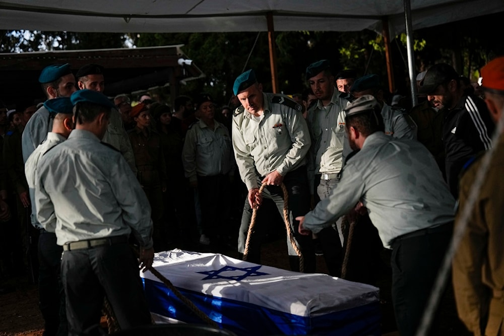Israeli occupation soldiers lower the flagged coffin of Israeli occupation soldier that died during confrontations with the Palestinian Resistance, occupied Palestine, Tuesday, Nov. 14, 2023. (AP)