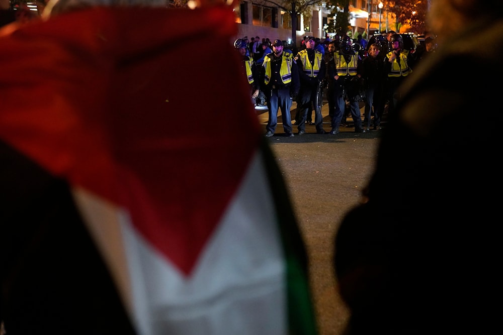 Candles lit by protesters line the street as U.S. Capitol Police officers stand outside the headquarters of the Democratic National Committee Wednesday, Nov. 15, 2023, in Washington. (AP)