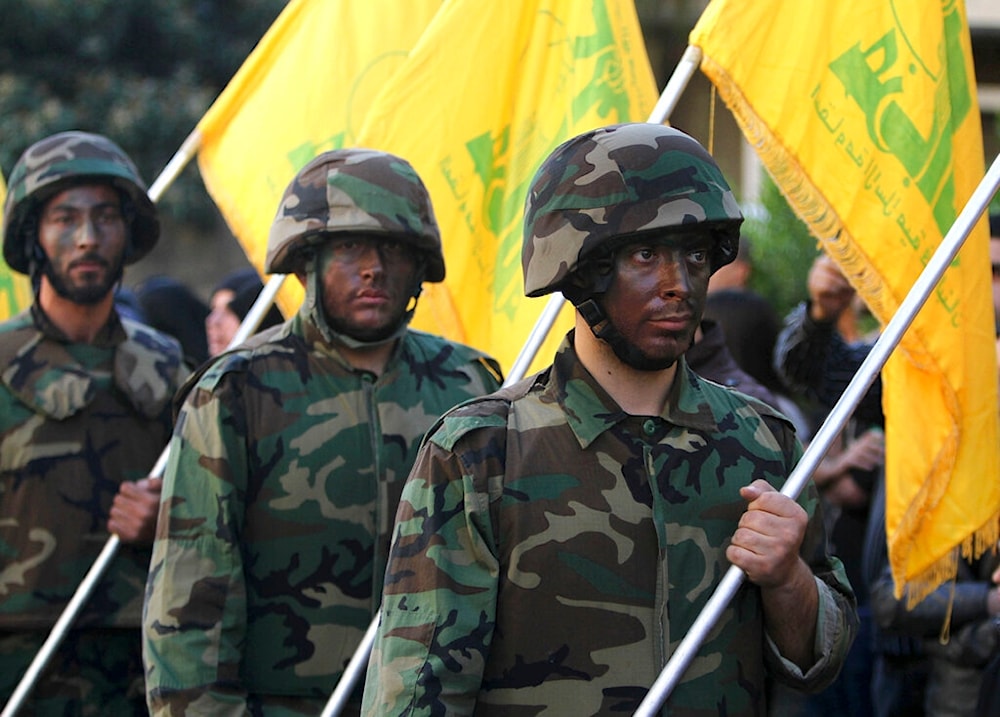Hezbollah fighters hold their party flags, as they parade during a rally to mark the 13th day of Ashoura in the southern market town of Nabatiyeh, Lebanon, Friday, Nov. 7, 2014 (AP)