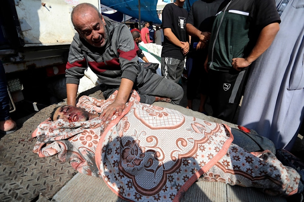 A Palestinian man mourns over the body of his relative who was killed in an Israeli airstrike, in the al-Shifa hospital in Gaza City, Sunday, Nov. 5, 2023 (AP)