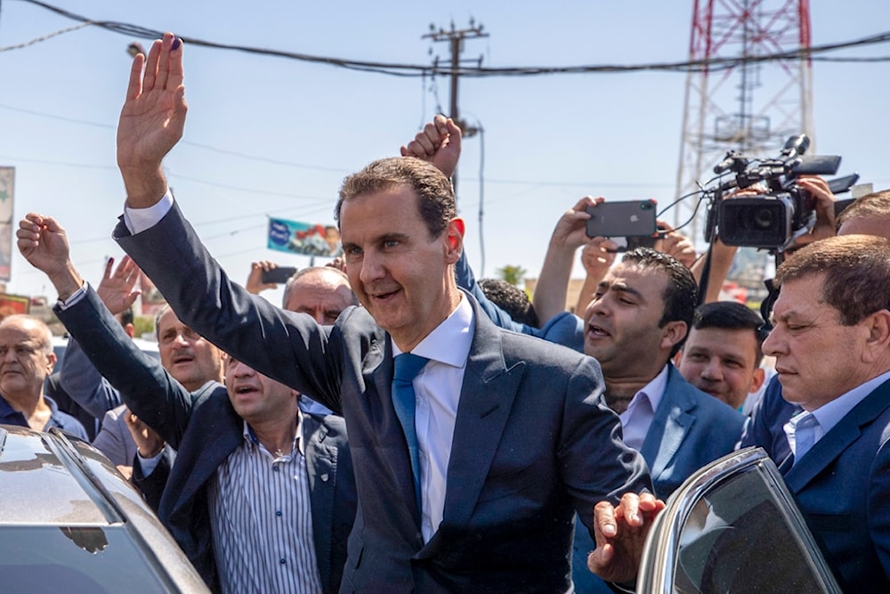 Syrian President Bashar Assad, waves to his supporters at a polling station during the Presidential elections in the town of Douma, in the eastern Ghouta region, near the Syrian capital Damascus, Syria, May 26, 2021. (AP)