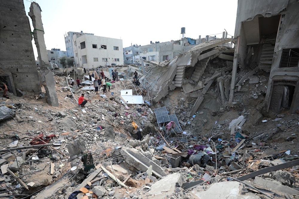 Palestinians look at destruction after an Israeli strike on the Gaza Strip in Nusseirat refugee camp, central Gaza Strip, Friday, Nov. 17, 2023 (AP Photo/Marwan Saleh)