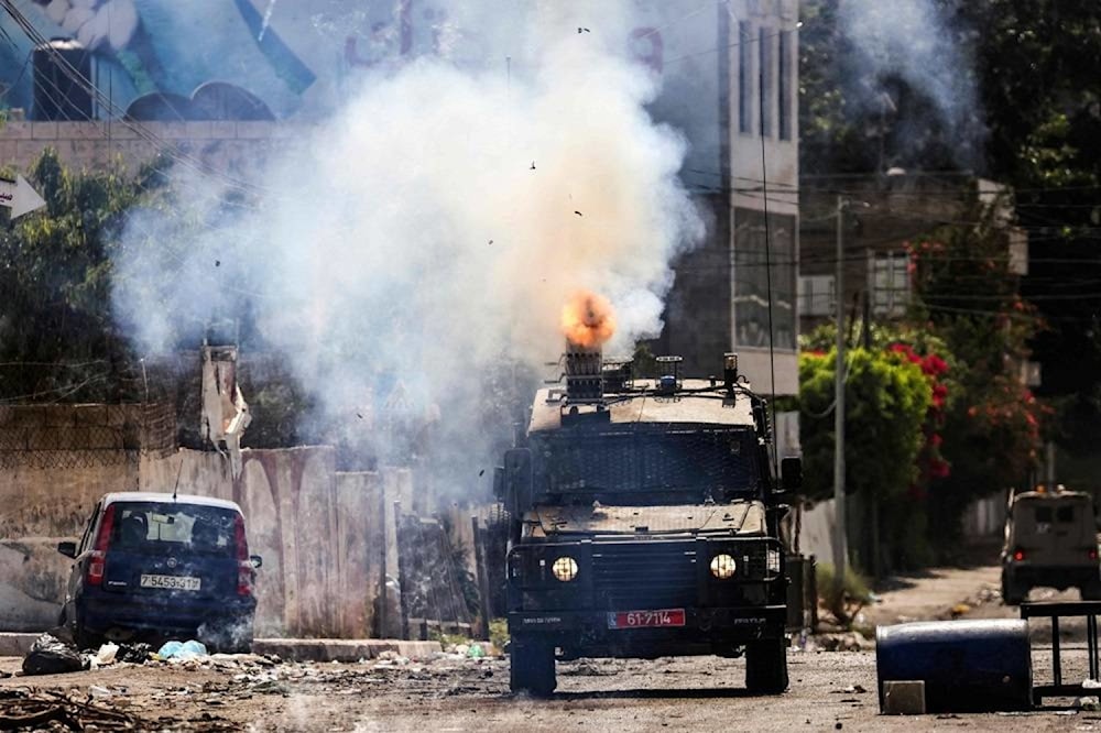 An Israeli armored vehicle fires tear gas during an ongoing military operation in Jenin city in the occupied West Bank on July 4, 2023. (AFP)