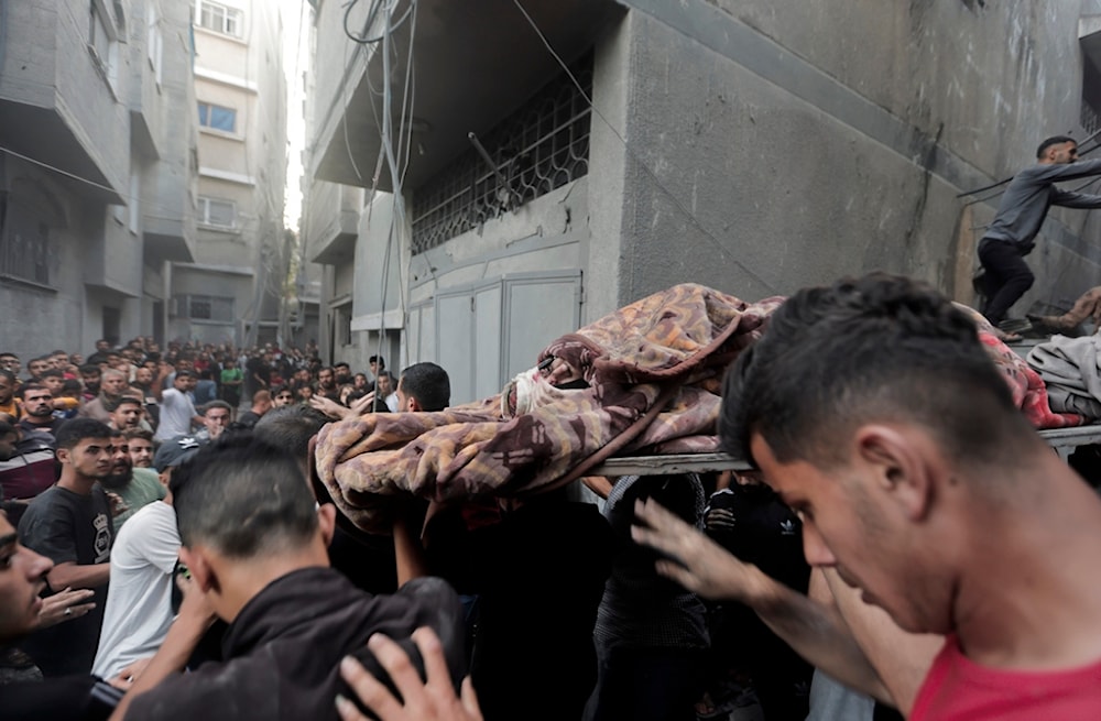 Palestinians evacuate an injured woman that was found under the rubble of a destroyed house following an Israeli airstrike in Khan Younis refugee camp, southern Gaza Strip, Saturday, Nov. 18, 2023 (AP Photo/Mohammed Dahman)