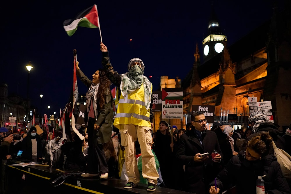 Protesters wave flags during a pro-Palestinian protest in front of the Houses of Parliament in London on Nov. 15, 2023. (AP)