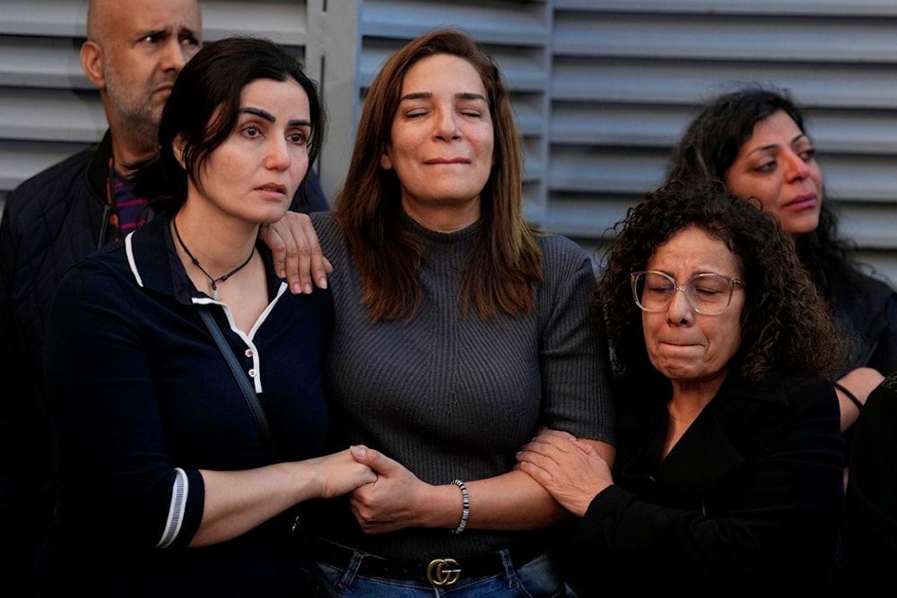 Colleagues of the two martyred Al Mayadeen journalists, who were killed by an Israeli strike, mourn outside the station's headquarters in Beirut, Lebanon, November 21, 2023 (AP)