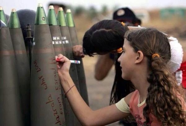 Israeli settler girls write messages on artillery ready to be fired at targets in southern Lebanon during the 2006 July war. (AFP)
