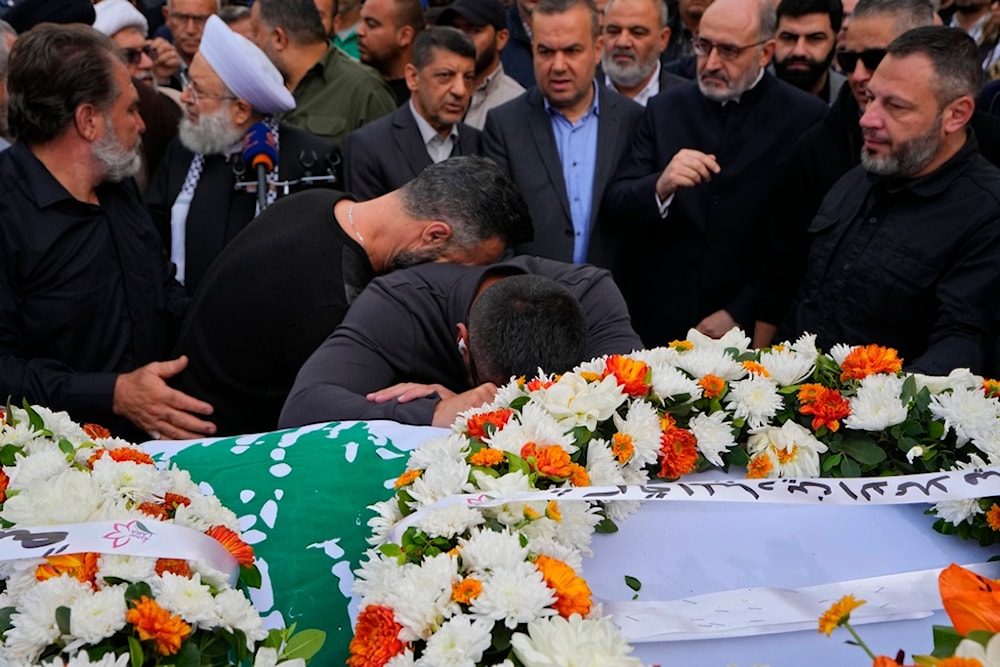 Mourners weep over the coffins of the two journalists of pan-Arab TV network Al-Mayadeen who were killed by an Israeli strike, during their funeral procession, at the station's headquarters, in Beirut, Lebanon, November 22, 2023 (AP)