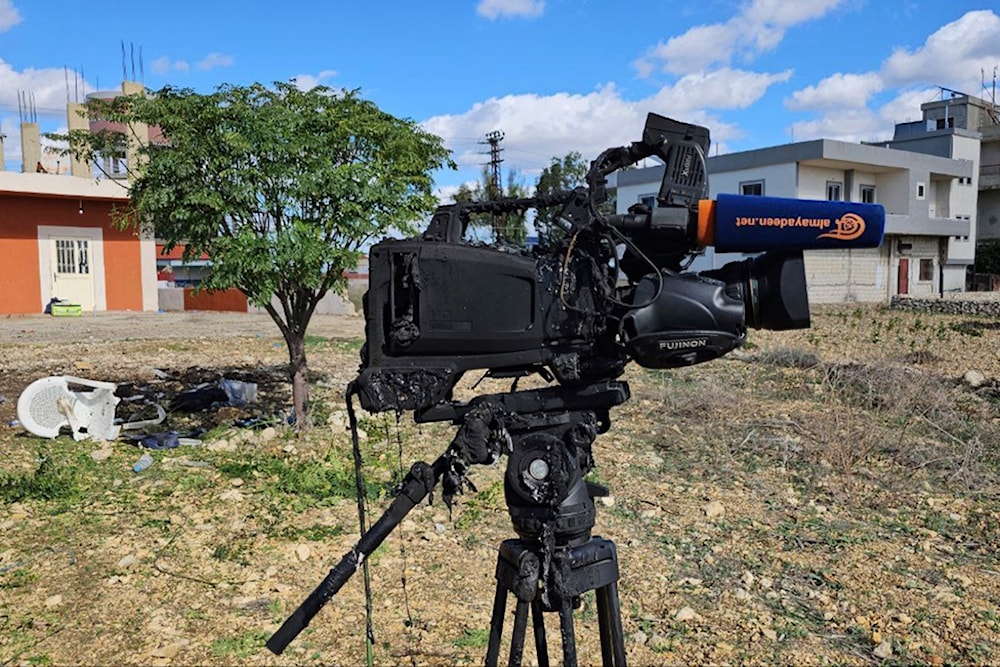 The damaged camera of Al Mayadeen cameraman Rabih Me'mari, who was killed in an Israeli strike, is seen at the Lebanese border village of Tayr Harfa near the border with occupied Palestine November 21, 2023 (AP)