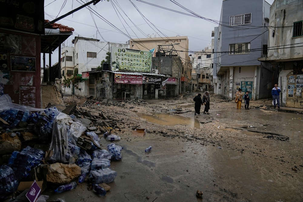 People walk by a destroyed road following an Israeli army operation in Jenin refugee camp, occupied West Bank, occupied Palestine, Sunday, Nov. 19, 2023. (AP)