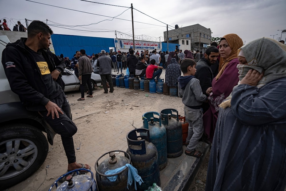 Palestinians line up for cooking gas during the second day of the temporary ceasefire imposed by the Palestinian Resistance on the Israeli occupation in Khan Yunis, Gaza Strip, November 25, 2023 (AP)