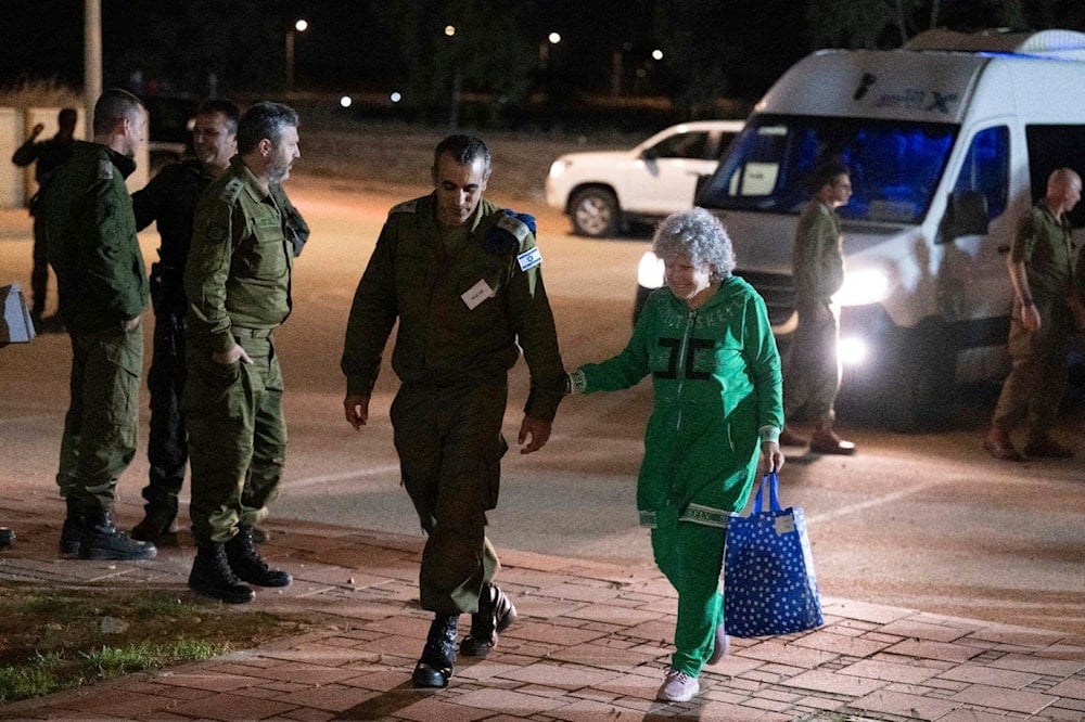 Ruth Munder, a released Israeli hostage, walks with an Israeli soldier shortly after her arrival in Israel on Friday, Nov. 24, 2023. 