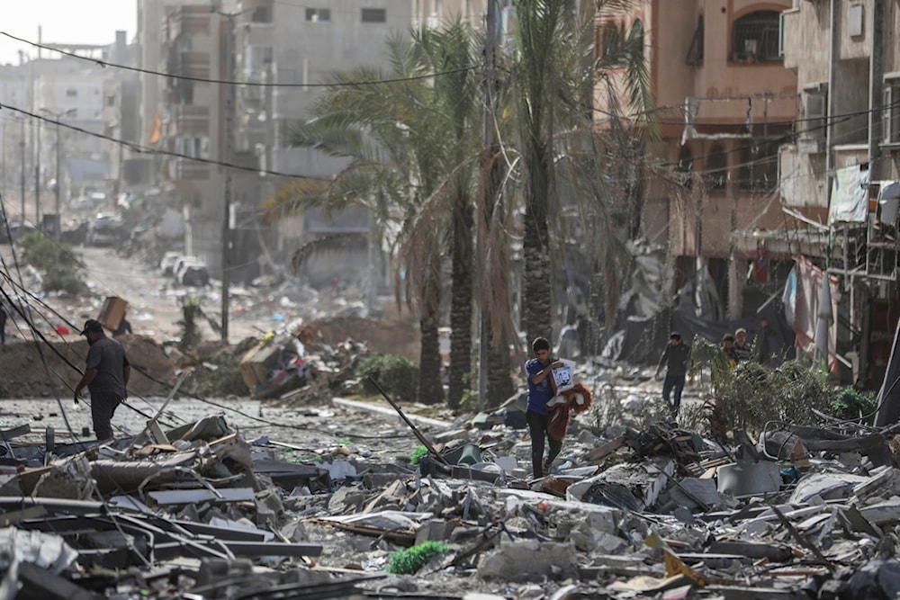 Palestinians walk through Gaza City on Sunday, Nov. 26, 2023 (AP Photo/Mohammed Hajjar)