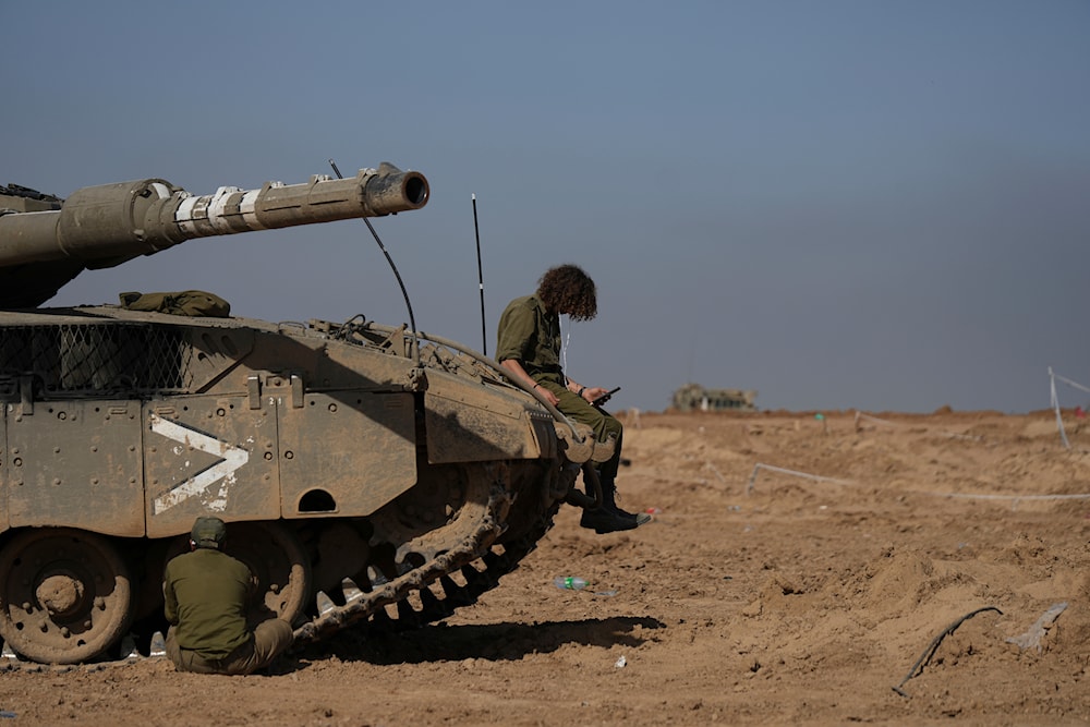 sraeli soldiers work on a tank in a staging area in southern 'Israel', near the border with Gaza Strip, on Friday, Nov. 24, 2023. (AP)