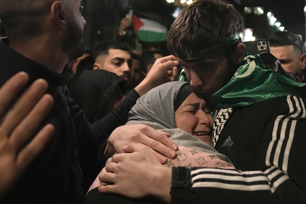Omar Atshan, 17, is hugged by his mother after being released from an Israeli prison in the West Bank town of Ramallah, Sunday Nov. 26, 2023 (AP)