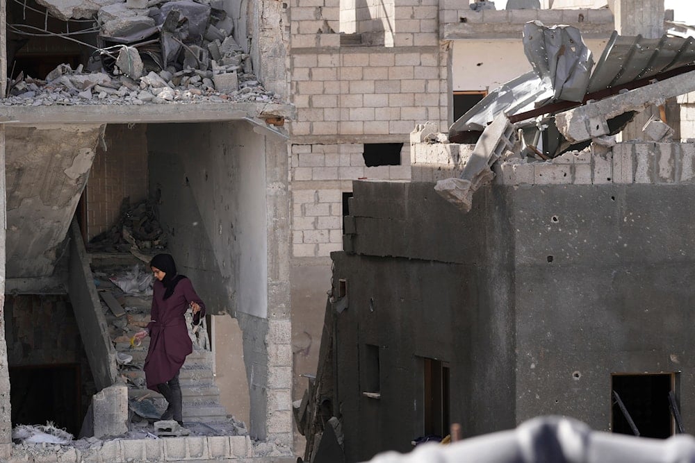 Palestinians visit their homes destroyed in the Israeli bombardment of the Gaza Strip in the village of Khuza'a, east of Khan Younis, Gaza Strip, Sunday, Nov. 26, 2023 (AP)