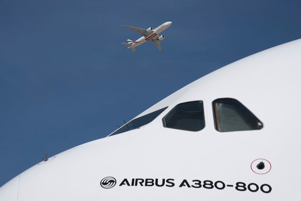 An Emirates cargo flight takes off over an Emirates Airbus A380 on display at the Dubai Air Show in Dubai, United Arab Emirates, Monday, Nov. 13, 2023. (AP)