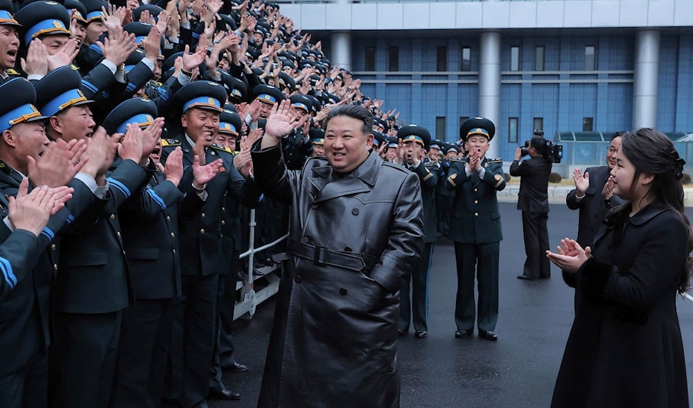 This photo provided by the North Korean government, North Korean leader, Kim Jong Un, center, and his daughter, right, meet staff of NATA for a group photo, following the launch of a spy satellite in Pyongyang, North Korea, on Nov. 23, 2023 (AP)