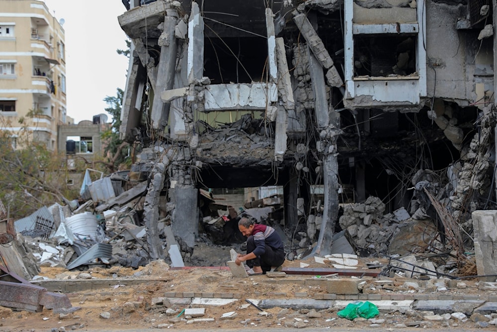 A Palestinian man works on the rubble of destroyed buildings in Beit Lahiya, Gaza Strip, Tuesday, Nov. 28, 2023. on the fifth day of the temporary ceasefire between Hamas and Israel. (AP Photo/Mohammed Hajjar)