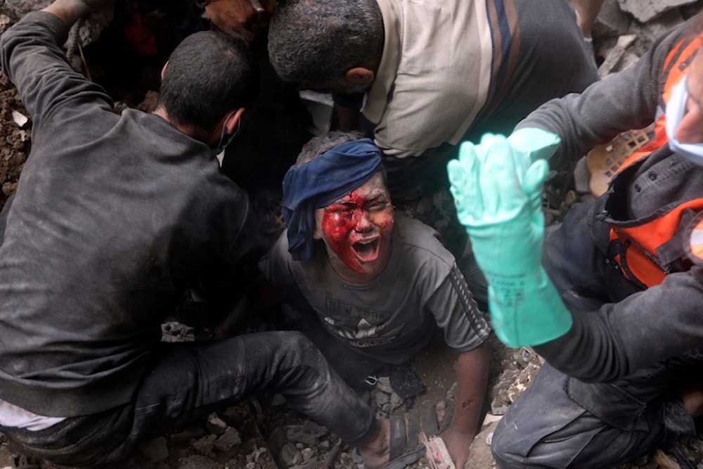 An injured Palestinian boy cries as rescuers try to pull him out of the rubble of a destroyed building following an Israeli airstrike in Breij refugee camp, Gaza Strip, Occupied Palestine, Thursday, Nov. 2, 2023. (AP)