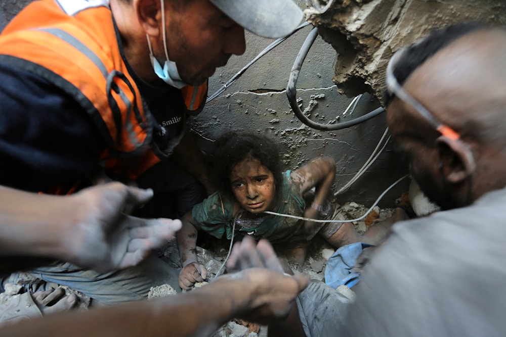 Palestinians try to pull a girl out of the rubble of a building that was destroyed by Israeli airstrikes in Jabalia refugee camp, northern Gaza Strip, Wednesday, Nov. 1, 2023. (AP)