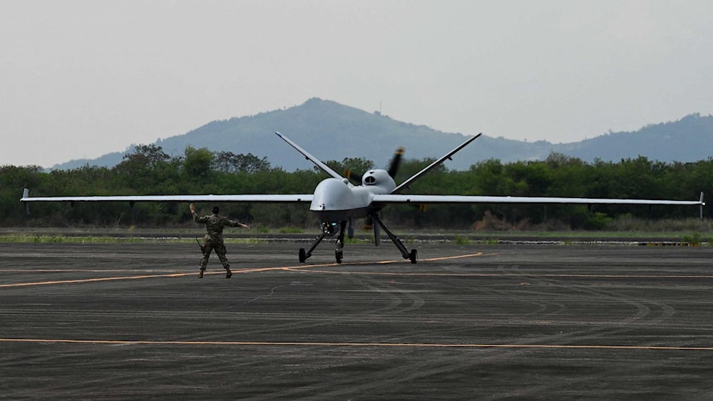 A US soldier guides the MQ-9 Reaper drone as it lands at Subic Bay Freeport Zone on April 23, 2023 (AFP)