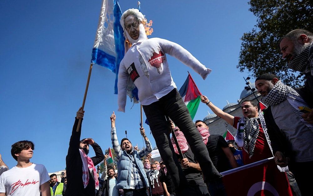 Protesters chant slogans while burning a doll with a picture of Prime Minister Benjamin Netanyahu in Istanbul, Turkey, October 20, 2023 (AP)