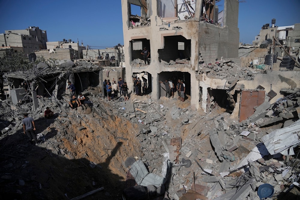 Palestinians look at buildings destroyed in the Israeli bombardment in the morgue in Deir al Balah, Gaza Strip, Tuesday, Nov. 7, 2023  (AP Photo/Hatem Moussa)