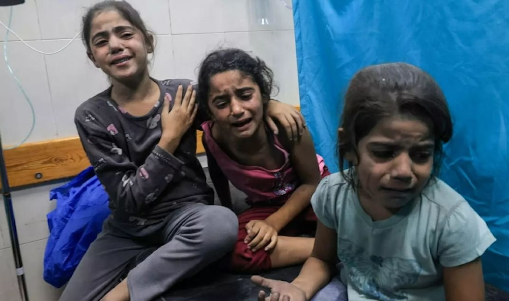 Palestinian children injured in an Israeli air strike await treatment at a hospital in Khan Yunis in southern Gaza, on 17 October 2023 (AFP)