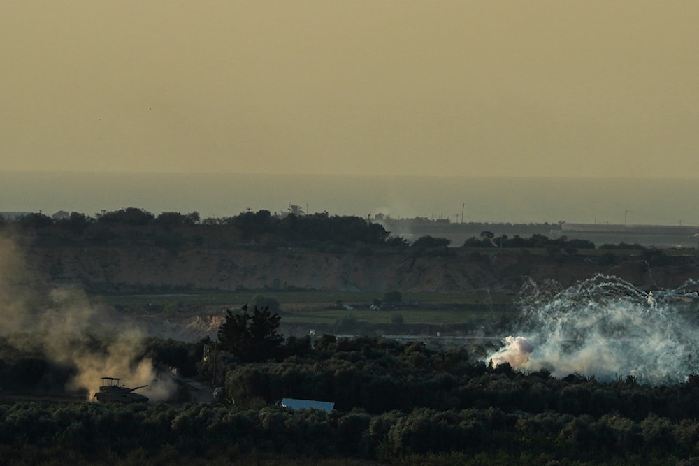 An Israeli tank operates in the Gaza Strip, as seen from southern occupied Palestine, October 30, 2023 (AP)