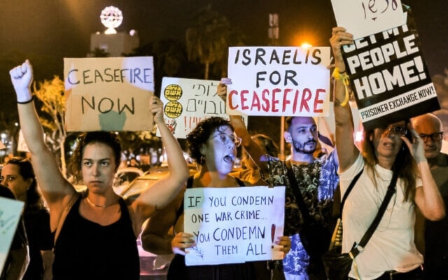 People gather with signs calling for a ceasefire during a protest for the release of Israeli captives in “Tel Aviv” on October 28, 2023. (AFP)