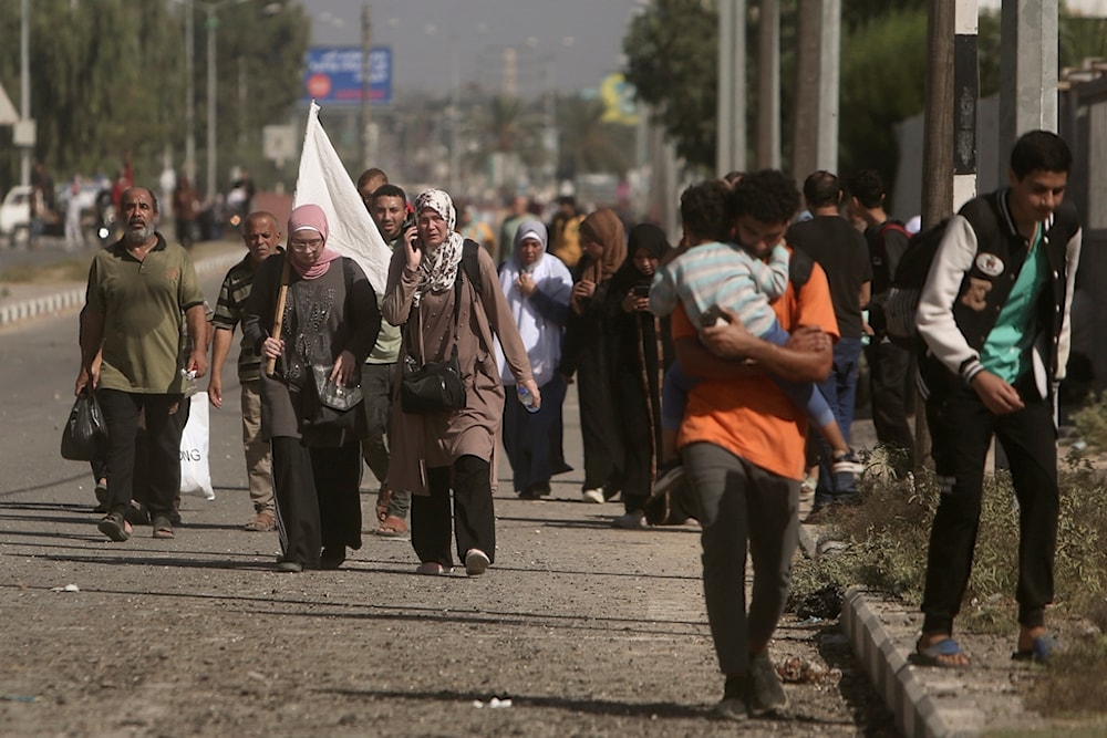 A woman carries a white flag to prevent being shot, as Palestinians flee Gaza City to the southern Gaza Strip on Salah al-Din Street in Bureij, Tuesday, Nov. 7, 2023 (AP)