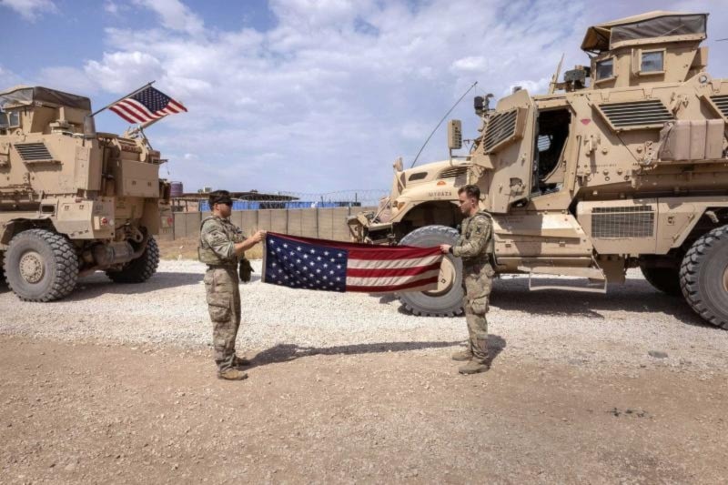 US occupation soldiers fold a flag after returning from patrol to a remote combat outpost known as RLZ on May 25, 2021 in northeastern Syria. (AFP)