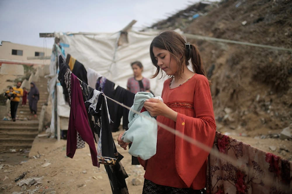 Palestinians resort to the sea water to bathe and clean their tools and clothes due the continuing water shortage in the Gaza Strip, on the beach of Deir al-Balah, Central Gaza Strip, Sunday, Oct. 29, 2023 (AP)