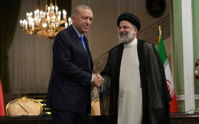 Turkish President Recep Tayyip Erdogan, left, and his Iranian counterpart Ebrahim Raisi shake hands at the conclusion of their joint press briefing at the Saadabad Palace, in Tehran, Iran, July 19, 2022. (AP)
